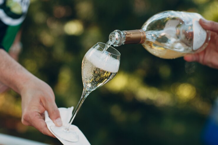 Cameriere versando champagne in un bicchiere
