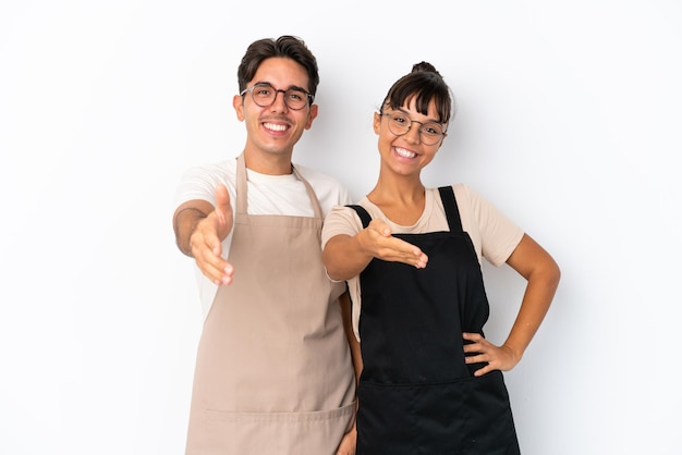 Camerieri di razza mista del ristorante isolati su sfondo bianco che stringono la mano per chiudere un buon affare