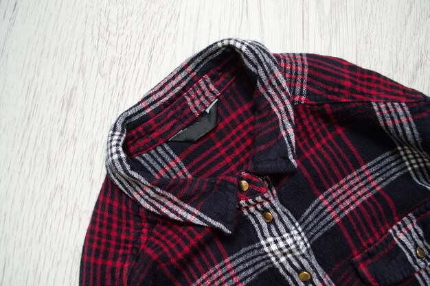 Camicia a scacchi, da vicino. Fondo in legno Concetto alla moda