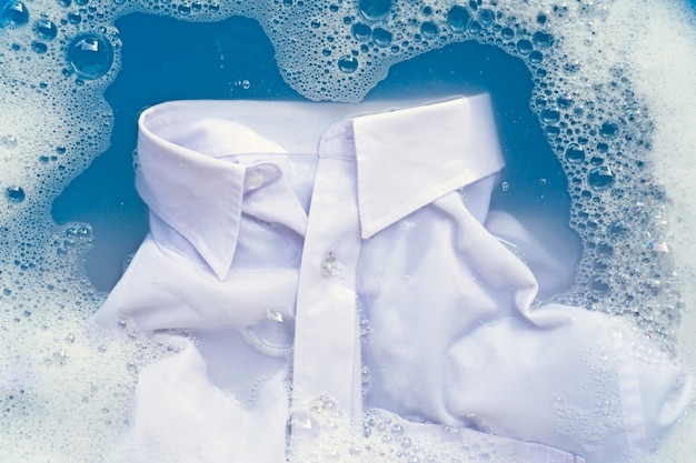 Camicia bianca immergere in soluzione di acqua detergente in polvere