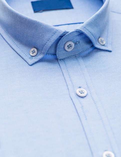 Camicia blu con focus su colletto e bottone, primo piano