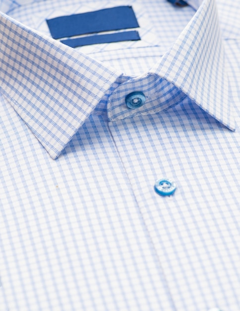 Camicia blu con motivo a scacchi e con un focus sul collo e bottone, primo piano