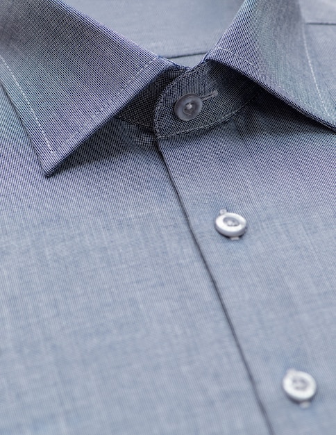 Camicia blu con particolare sul colletto e bottone, primo piano