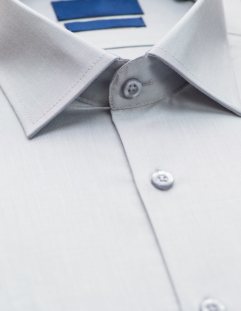 Camicia grigia con particolare sul colletto e sul bottone, primo piano