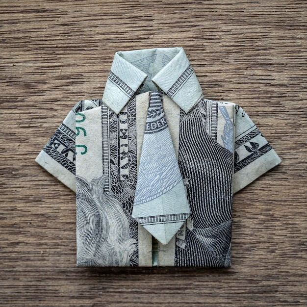 Camicia origami fatta di banconote in dollari su sfondo di legno Closeup Dollar Bill Tshirt