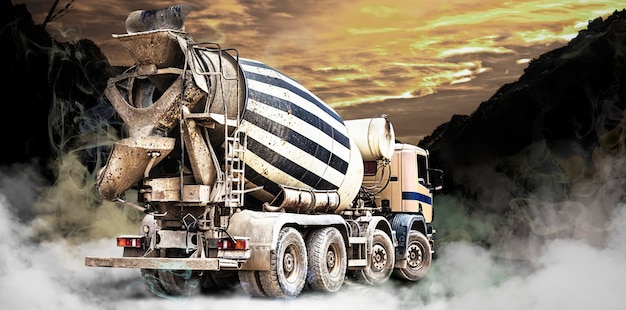 Camion betoniera in un cantiere edile in fumo o nebbia Consegna di calcestruzzo per gettare fondazioni e strutture edili Concetto per pubblicità e design Trasporto di calcestruzzo