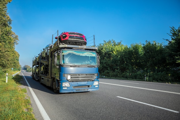 Camion bianco arrivante sulla strada in un paesaggio rurale al tramonto