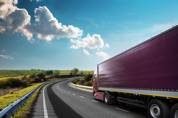 Camion bianco arrivante sulla strada in un paesaggio rurale al tramonto