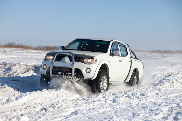 Camion bianco che viaggia nella neve