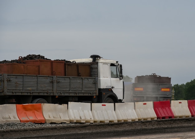 Camion che trasportano merci lungo una strada in costruzione.