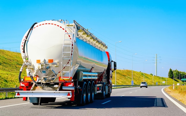 Camion con deposito di liquidi o olio in strada o autostrada della Polonia. Autocarro con cisterna di servizio al lavoro di logistica. Cisterna semirimorchio. Azionamento in auto da carico. Consegna merci. Industria dell'esportazione dei trasporti