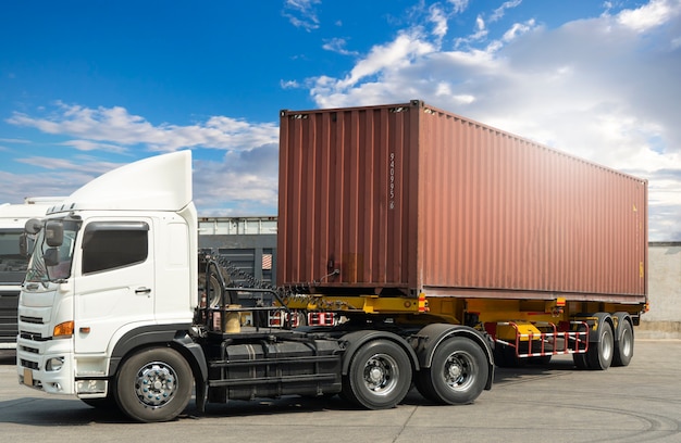 Camion con rimorchio con container di carico parcheggio presso il trasporto di camion merci dell'industria del cielo blu