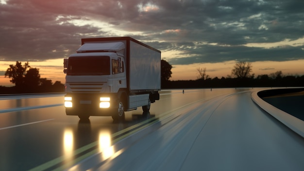 Camion di consegna bianco su strada asfaltata al tramonto