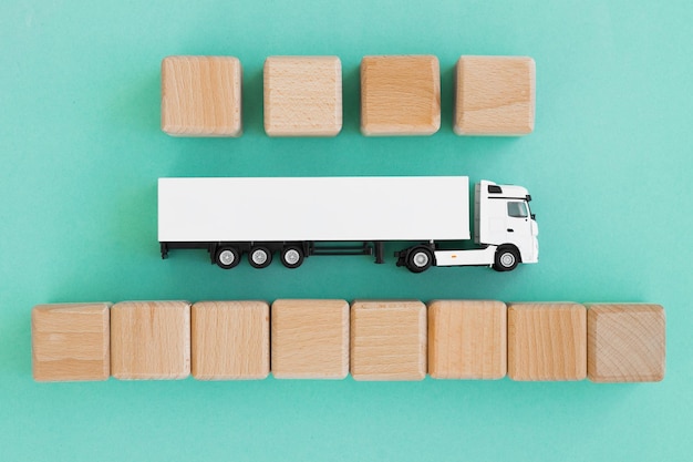 Camion giocattolo con cubi di legno isolati su turchese Concetto di logistica e commercio all'ingrosso