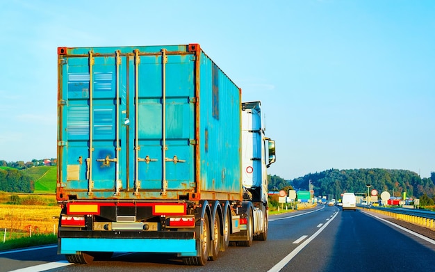 Camion in strada estiva della Polonia. Camionista in autostrada. Camion che fa lavori di logistica. Semirimorchio con conducente. Grande auto da carico. Consegna merci. Industria dell'esportazione dei trasporti. Contenitore con merci