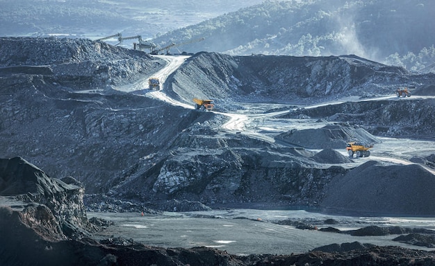 Camion minerari che lavorano nel paesaggio industriale della cava di pietra