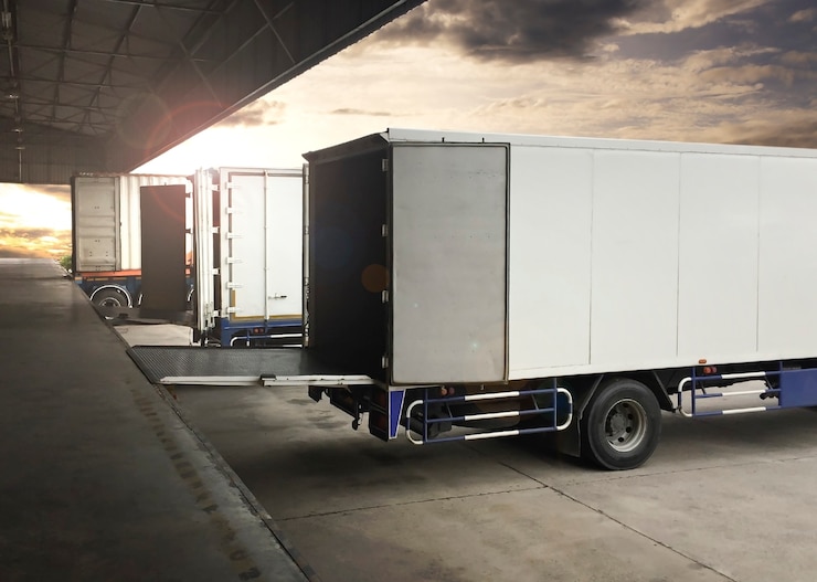 camion parcheggiati che caricano al magazzino del bacino di spedizione di merci industria del trasporto di camion