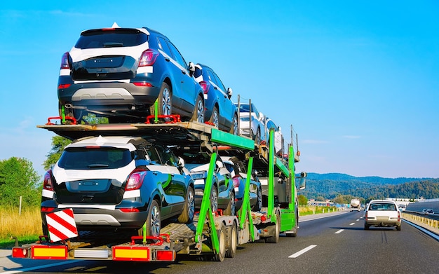 Camion per auto su strada o autostrada della Polonia. Camion trasportatore al lavoro di logistica. Rimorchio con trazione Cargo. Consegna per l'industria dell'esportazione dei trasporti. Trasportatore pesante. Trasportare il veicolo. Autotrasporto.