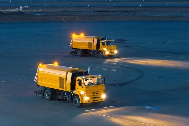 Camion per la pulizia dei rifiuti dalle strade dell'aeroporto di notte