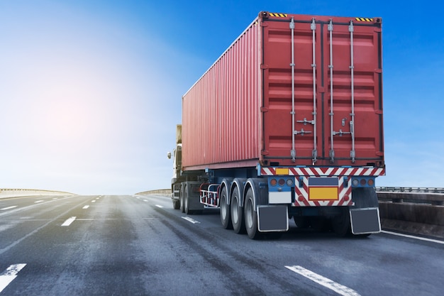 Camion sulla strada statale con contenitore rosso. Trasporto sull&#39;asfalto