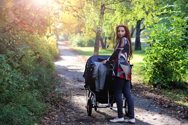 Cammina le donne con la luce solare estiva del passeggino