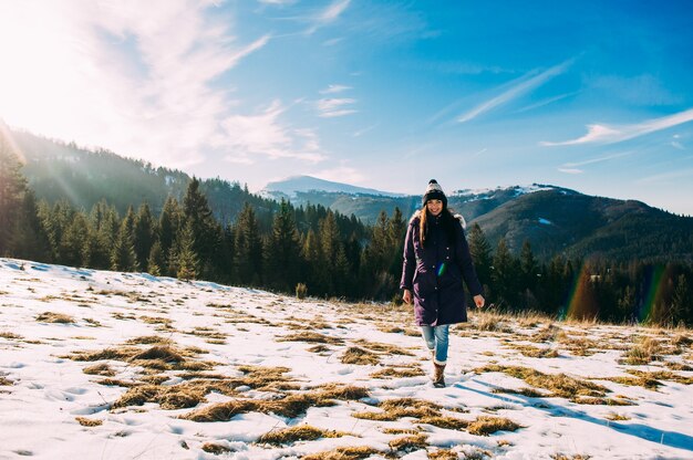 camminare in montagna, una bella ragazza su uno sfondo di montagne innevate