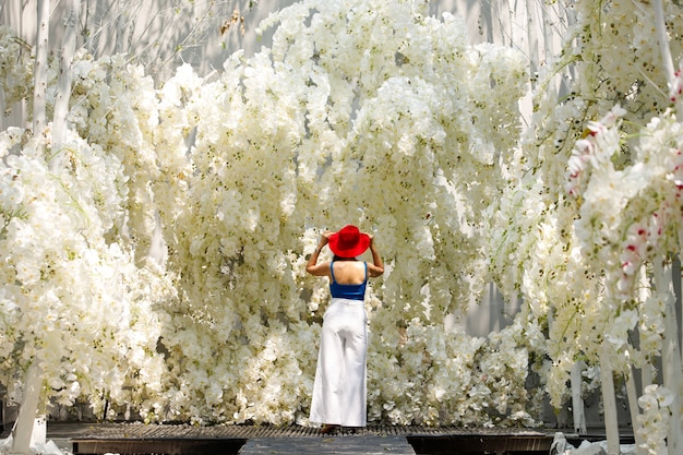 Camminata della donna nel campo bianco di sogno del fiore di fantasia con bei colori nella primavera di estate