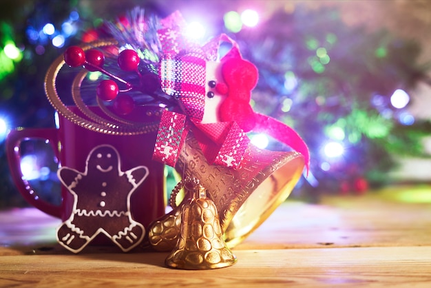 Campane di Natale d'oro tazza di caffè e biscotto sopra l'albero di Natale decorato