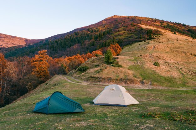 Campeggio con due tende turistiche in montagna. Paesaggio autunnale