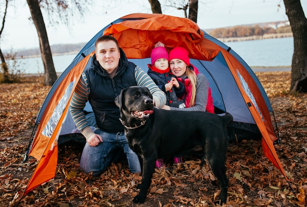 Campeggio in tenda - famiglia con cane campeggio nella foresta di autunno