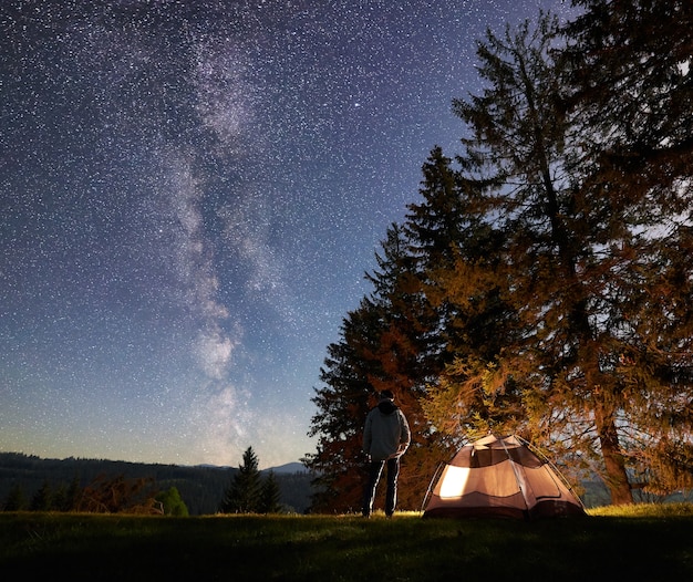 Campeggio notturno in montagna sotto il cielo stellato e la Via Lattea