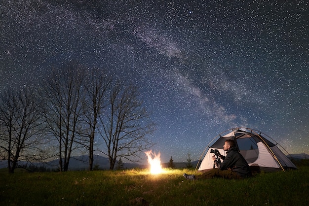 Campeggio notturno in montagna sotto il cielo stellato e la Via Lattea