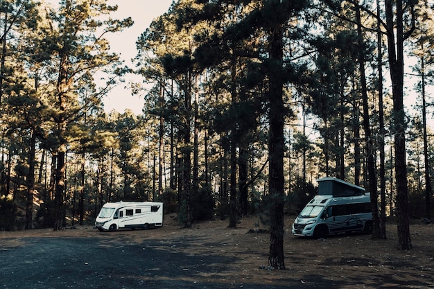 Campeggio selvaggio con un paio di camper parcheggiati Destinazione boschiva selvaggia e panoramica per viaggi di trasporto e stile di vita vanlife