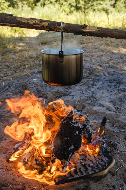 Campeggio, una pentola d'acqua bolle sul fuoco.