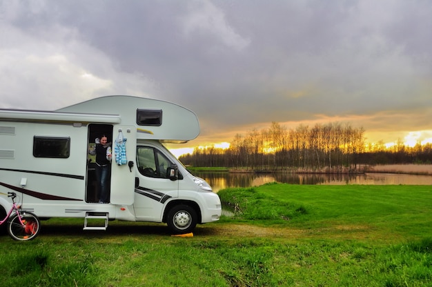 Camper camper e donna in campeggio al tramonto vacanza in famiglia viaggio vacanza in camper