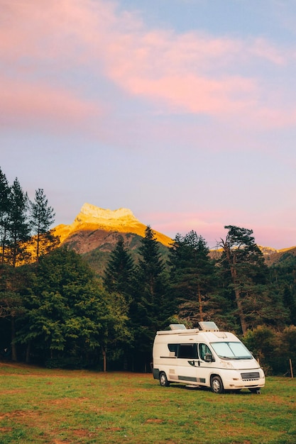 Camper con vista mozzafiato sulla foresta e sulle montagne durante il tramonto Vacanza in viaggio su strada in furgone