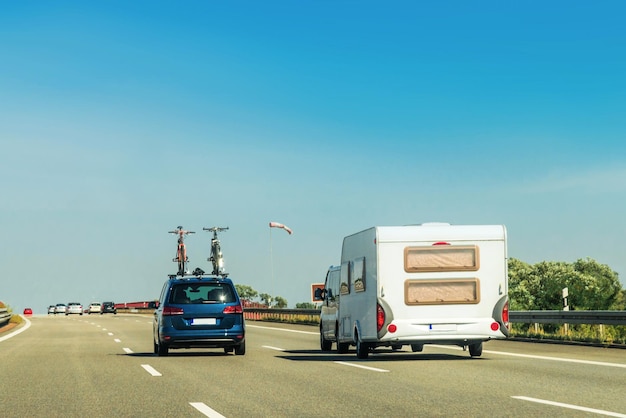 Camper RV con biciclette e auto su strada. Roulotte e camper in viaggio in Svizzera.