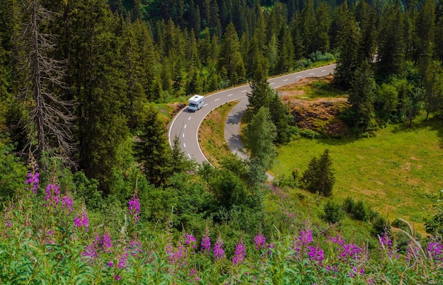 Camper Van Summer Travel Rving Photo Theme Piccolo camper di classe C su una strada di montagna durante l'estate