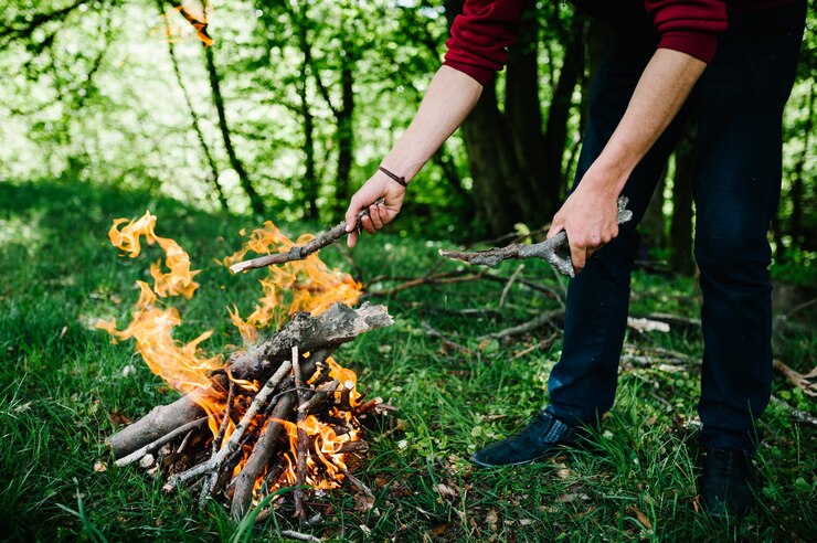 Photo campfire on the nature. man's hands. firewood preparation for fire