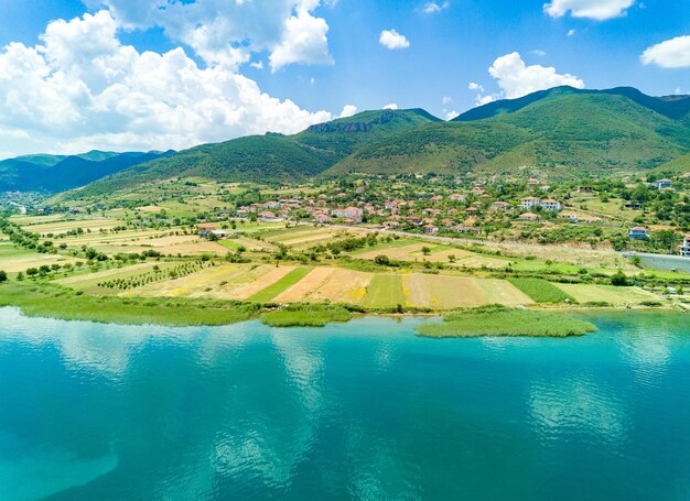 Campi coltivati a grano vicino ai villaggi montenegrini sulla costa del mare Adriatico sullo sfondo delle montagne balcaniche e del cielo