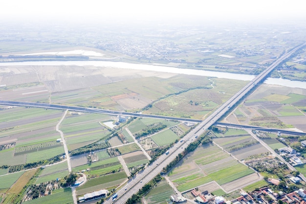 Campi con vari tipi di agricoltura e villaggi accanto all'inquinamento atmosferico nella mattina d'inverno, Tainan, Taiwan, vista aerea