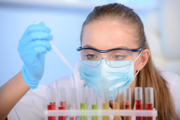 Campione di prova della donna del chimico di liquido in laboratorio