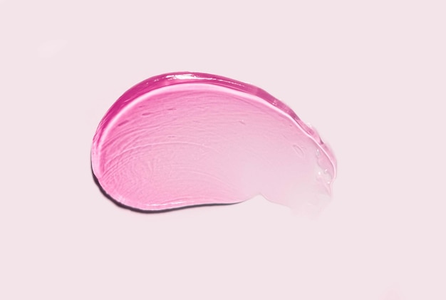 Campione di sbavature di colore gel rosa lucidalabbra isolato su sfondo rosa