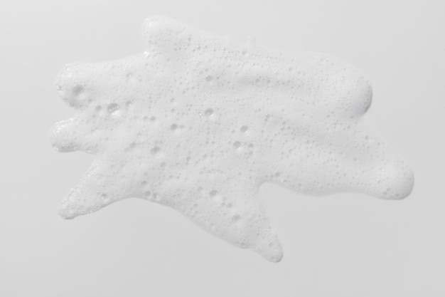 Campione di schiuma su sfondo bianco Texture liquida e sapone con bolle