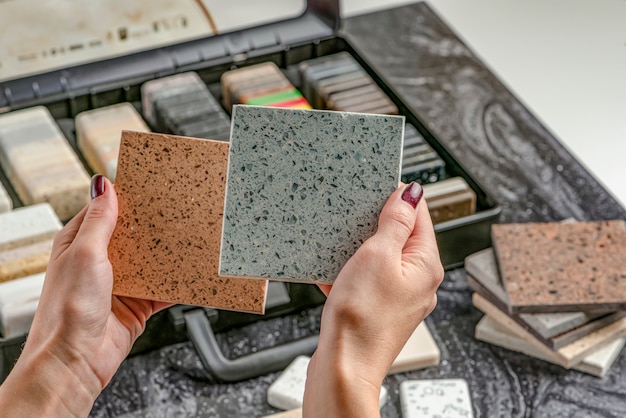 Campioni di materiale per le mani femminili del piano di lavoro scelgono elementi interni per la ristrutturazione sa...