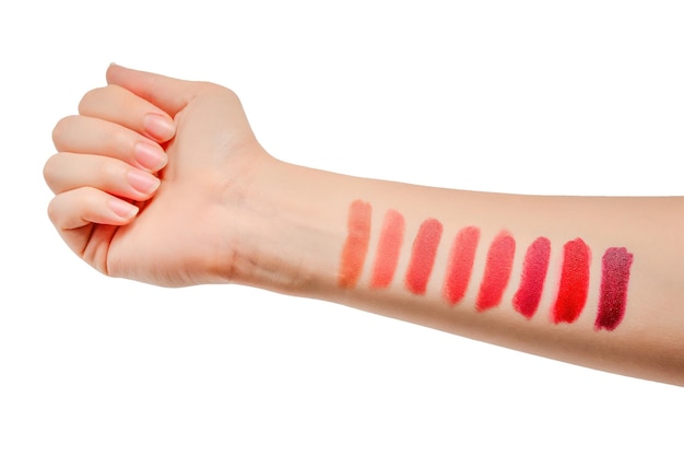 Campioni di rossetto sulla mano della donna isolato su sfondo bianco