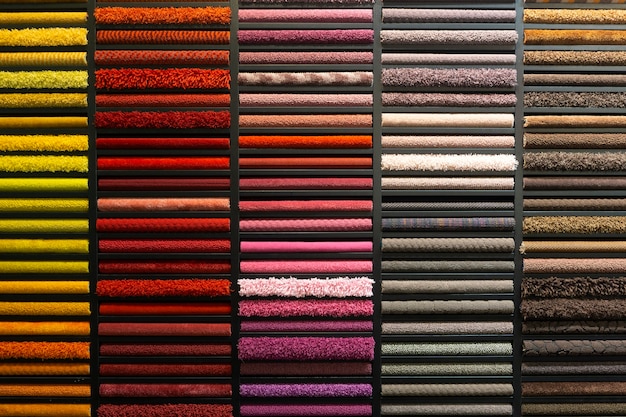 Campioni di tappeti di diversi colori su uno stand in un negozio o in una produzione. Campioni di moquette multicolore sul pavimento