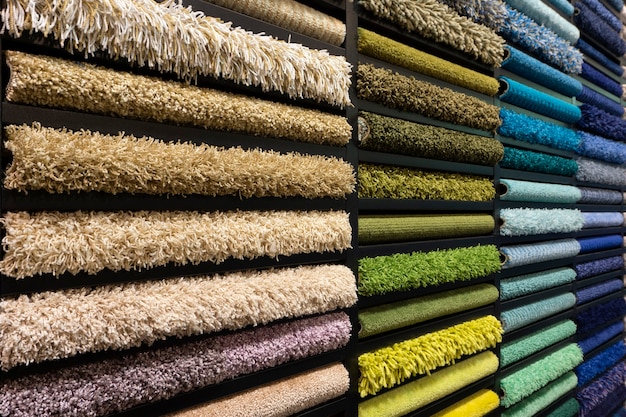 Campioni di tappeti di diversi colori su uno stand in un negozio o in una produzione. Campioni di moquette multicolore sul pavimento