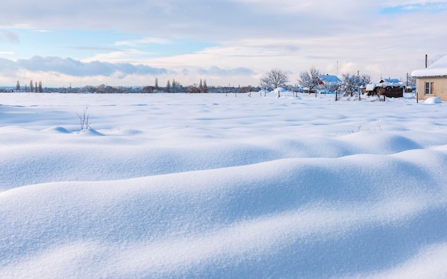 Campo agricolo ai margini del villaggio coperto di neve profonda