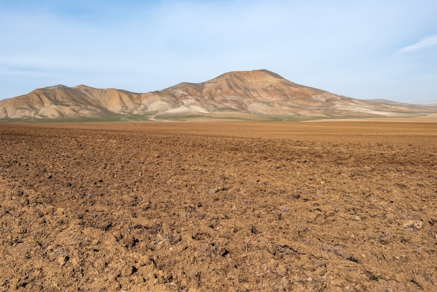 Campo agricolo arato nella valle di montagna